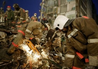 Работники МЧС пытаются вытащить мужчину из-под завалов стеллажей в складском помещении